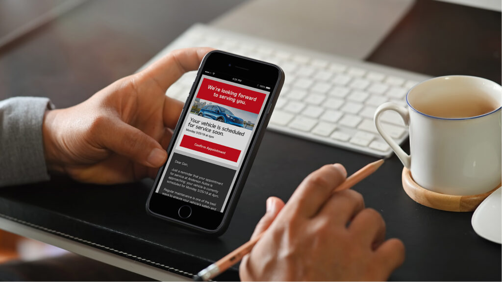 Guy on cell phone looking at car service email