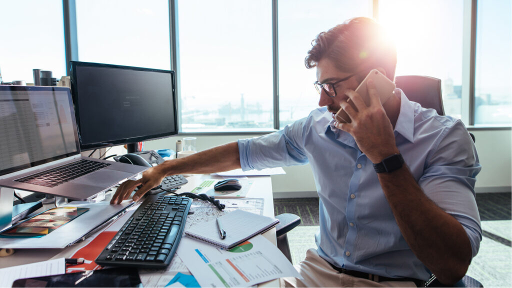 Guy on phone and computer at office