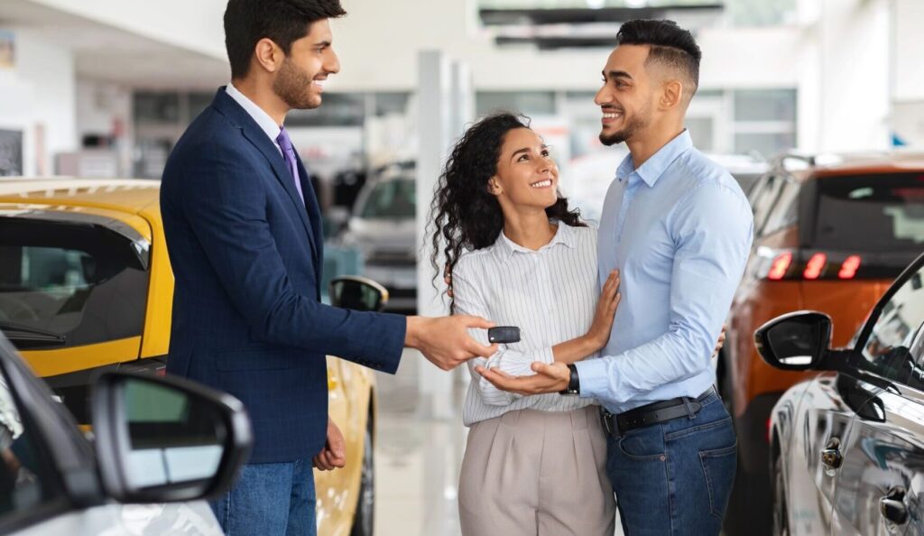 A salesperson hands over keys to a customer after employing a successful customer communication strategy.