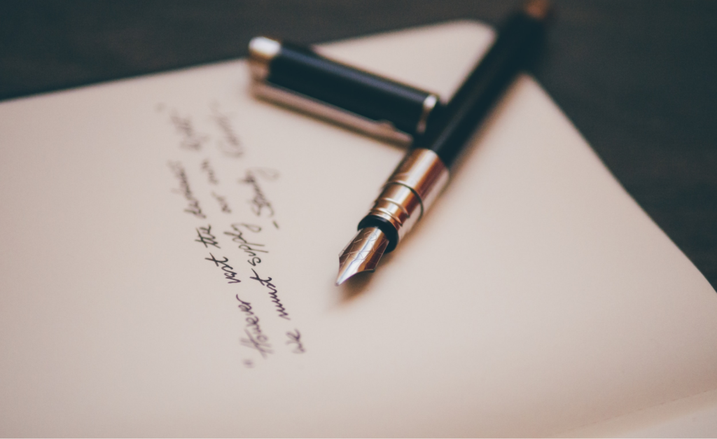 A dealer uses a pen to create a piece of automotive direct mail.