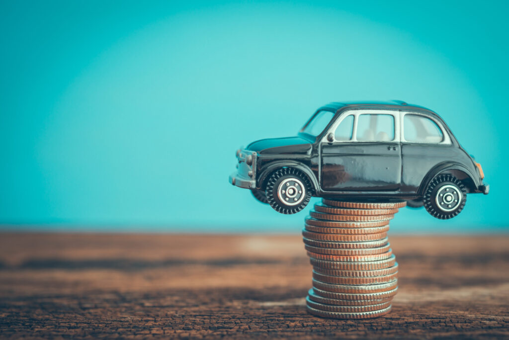 A CPO program represented by a toy car sitting on coins.