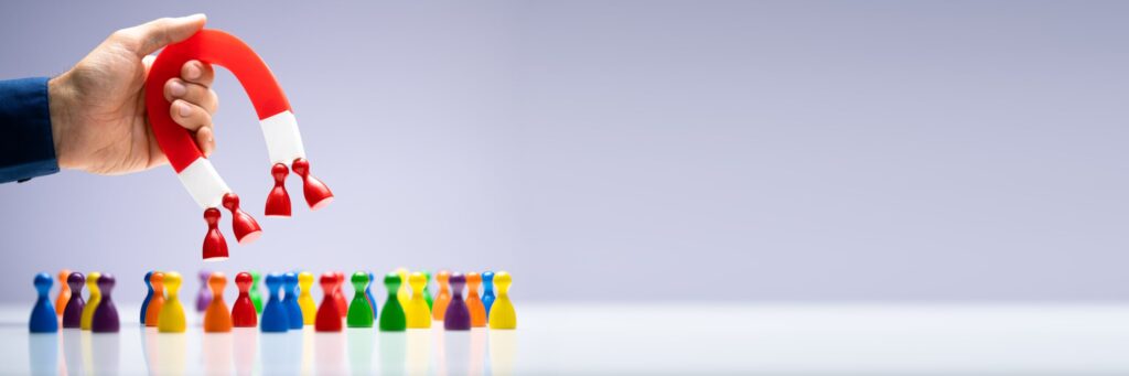 Car sales lead generation represented by a magnet attracting chess pieces.