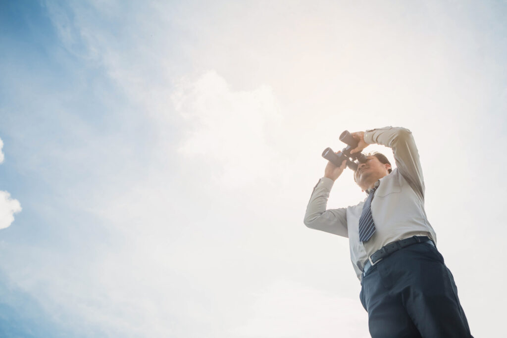A competitive landscape analysis represented by a man looking through binoculars.